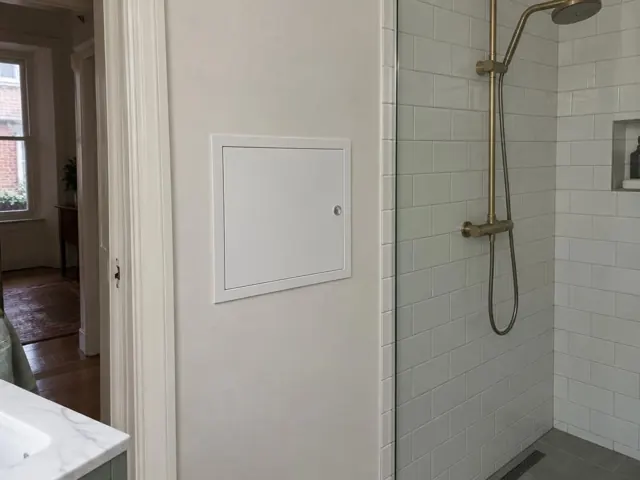 Neat wall access panel beside a tiled shower in a bathroom in Woollahra